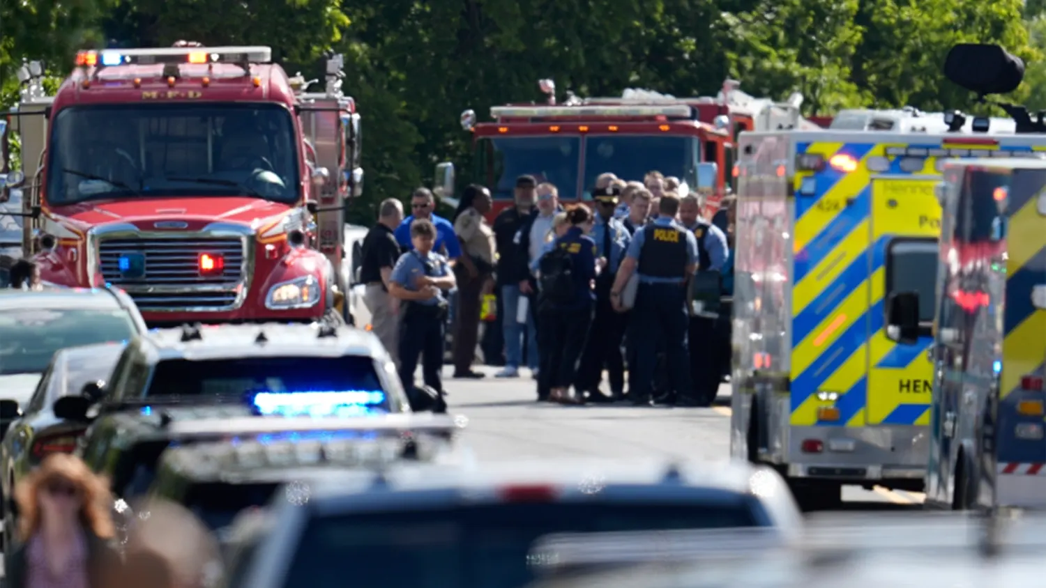 Multiple emergency response vehicles, including police cars, ambulances, and fire trucks, line a residential street in Minneapolis following a shooting at Annunciation Catholic School on August 27, 2025.