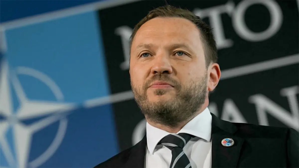 Estonian Foreign Minister Margus Tsahkna speaking at a NATO press conference with a digital map graphic behind him depicting the September 20, 2025 Estonian airspace breach incident by a Russian fighter jet and subsequent F-35 escort response