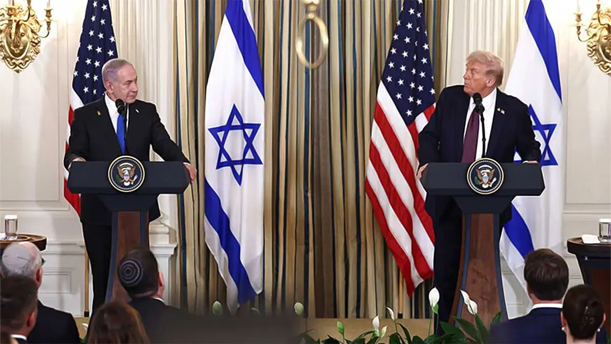 Donald Trump and Israeli Prime Minister Benjamin Netanyahu standing at separate podiums with presidential seals during a joint press conference. United States and Israeli flags stand in the background as the two leaders look toward one another.