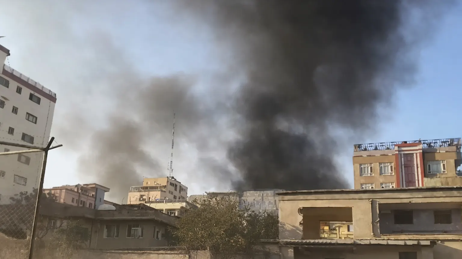 Black smoke rises over residential buildings in an Afghan city following reported airstrikes amid escalating cross-border tensions