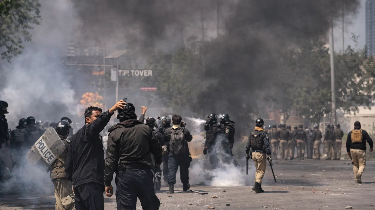 Police clash with protesters amid tear gas and smoke in Karachi, Pakistan during civil unrest in March 2026