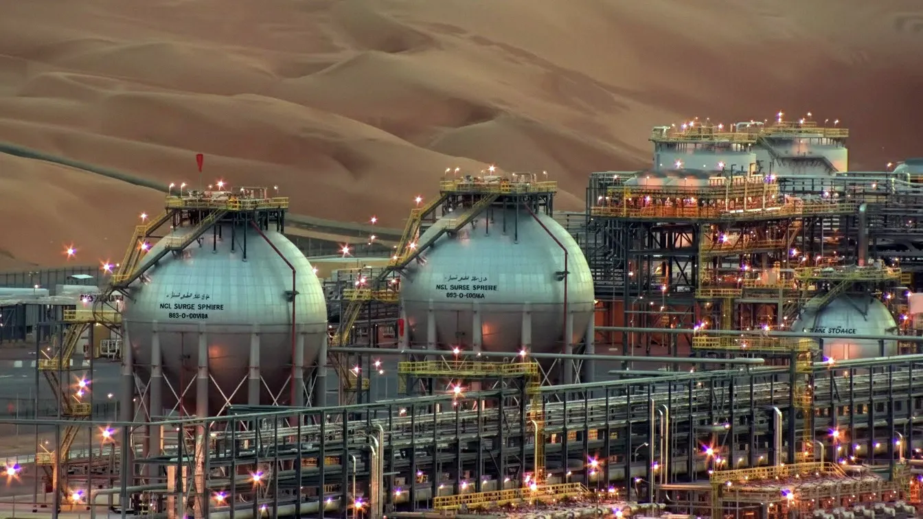 Spherical oil storage tanks at the Ras Tanura refinery against desert dunes at dusk