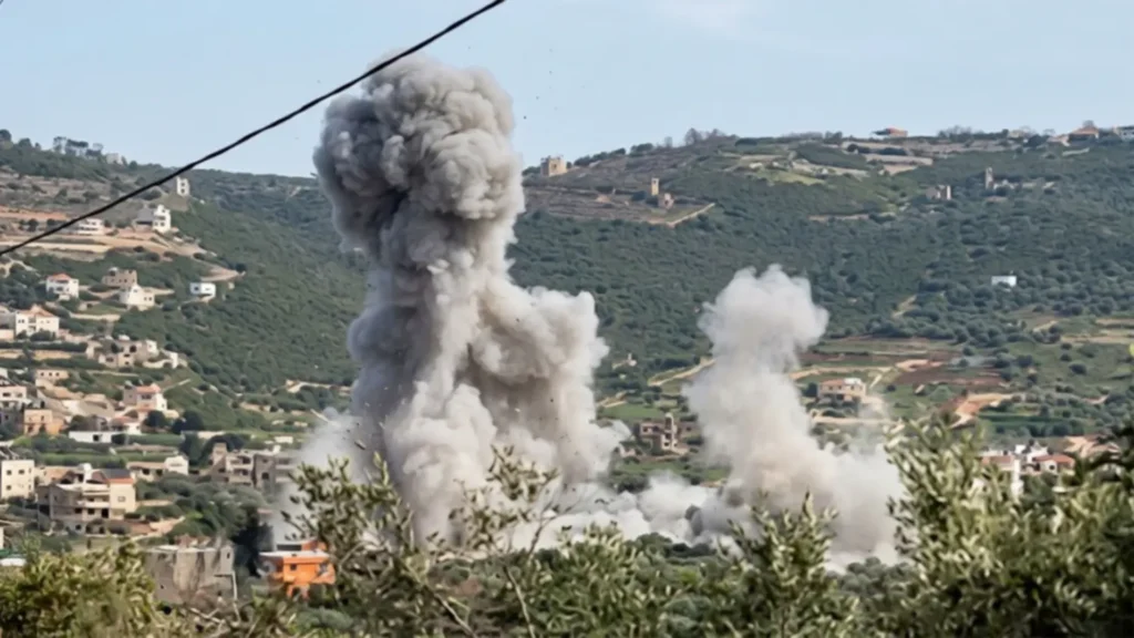 A high-resolution photo of massive grey smoke plumes rising from a hillside village in southern Lebanon following an Israeli airstrike during the 2026 ceasefire