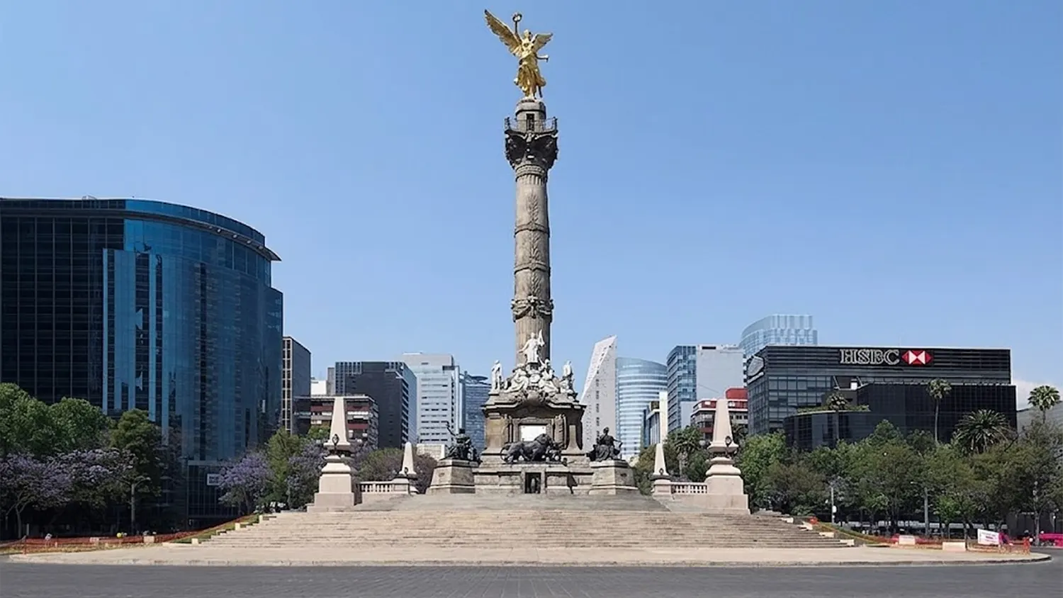 Wide shot of the Angel of Independence monument on Paseo de la Reforma in Mexico City with no people, showing the stone steps added due to land subsidence