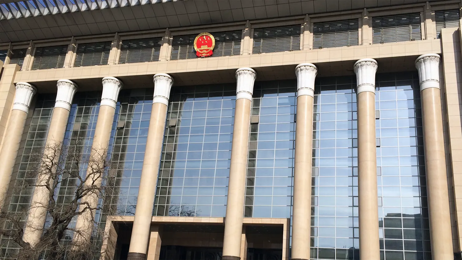 Exterior view of a Chinese court building with large pillars and the national emblem, representing recent legal rulings against AI-driven employee layoffs