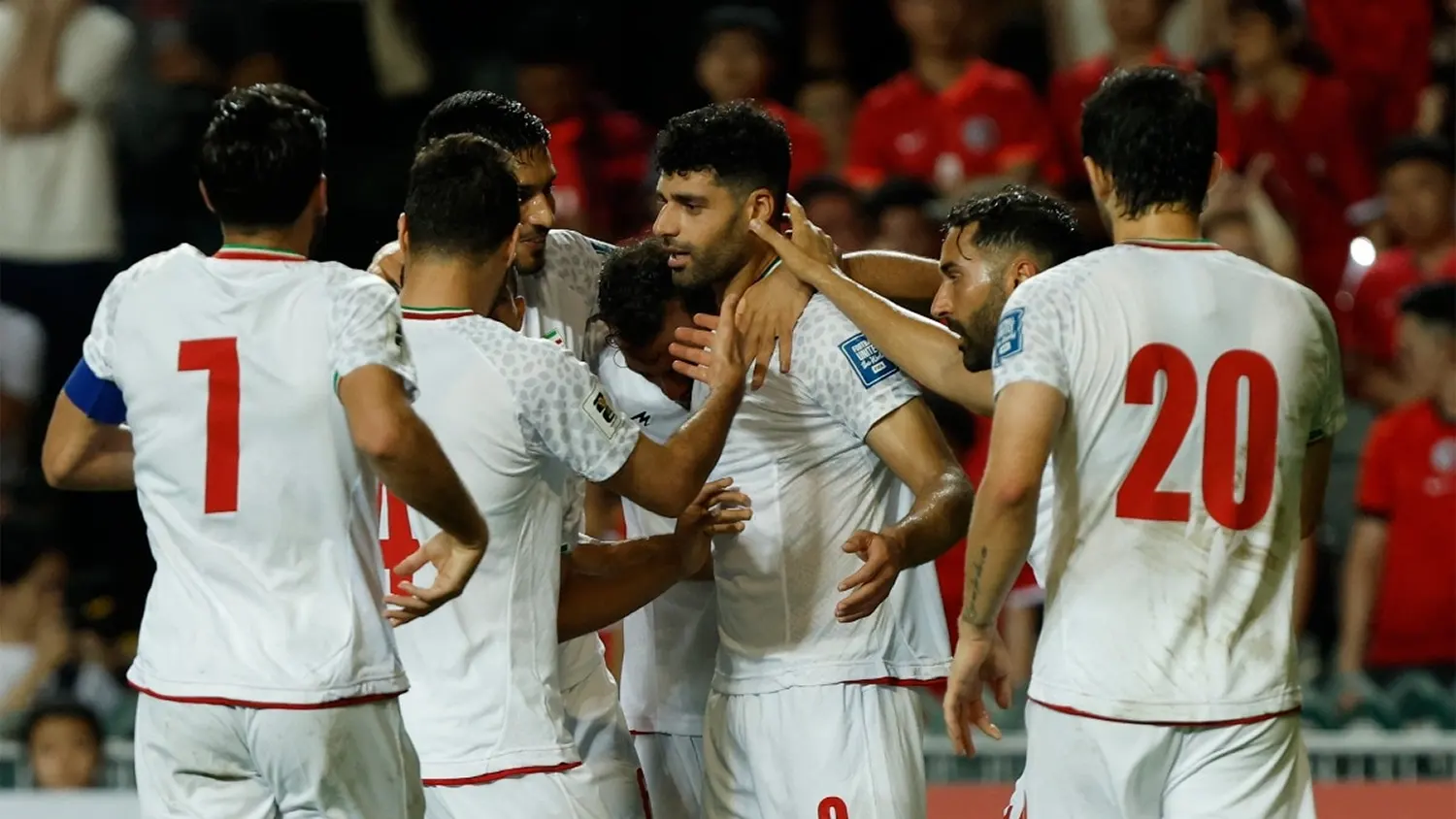 Iran national football team players in white jerseys celebrating a goal during a World Cup qualifying match
