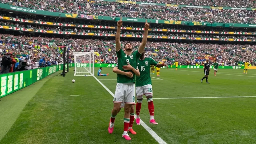 Mexico forward Raúl Jiménez pointing to the sky in celebration after scoring a second-half header against South Africa at the 2026 FIFA World Cup inside Estadio Azteca.