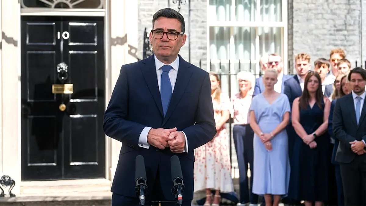 UK Prime Minister Andy Burnham wearing glasses and a navy blue suit, speaking at a podium outside 10 Downing Street.