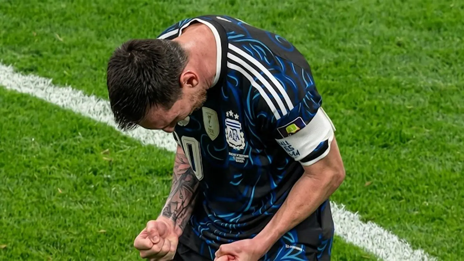 Lionel Messi clenching his fists and celebrating intensely on the pitch in an Argentina jersey during the 2026 World Cup semifinal match against England.