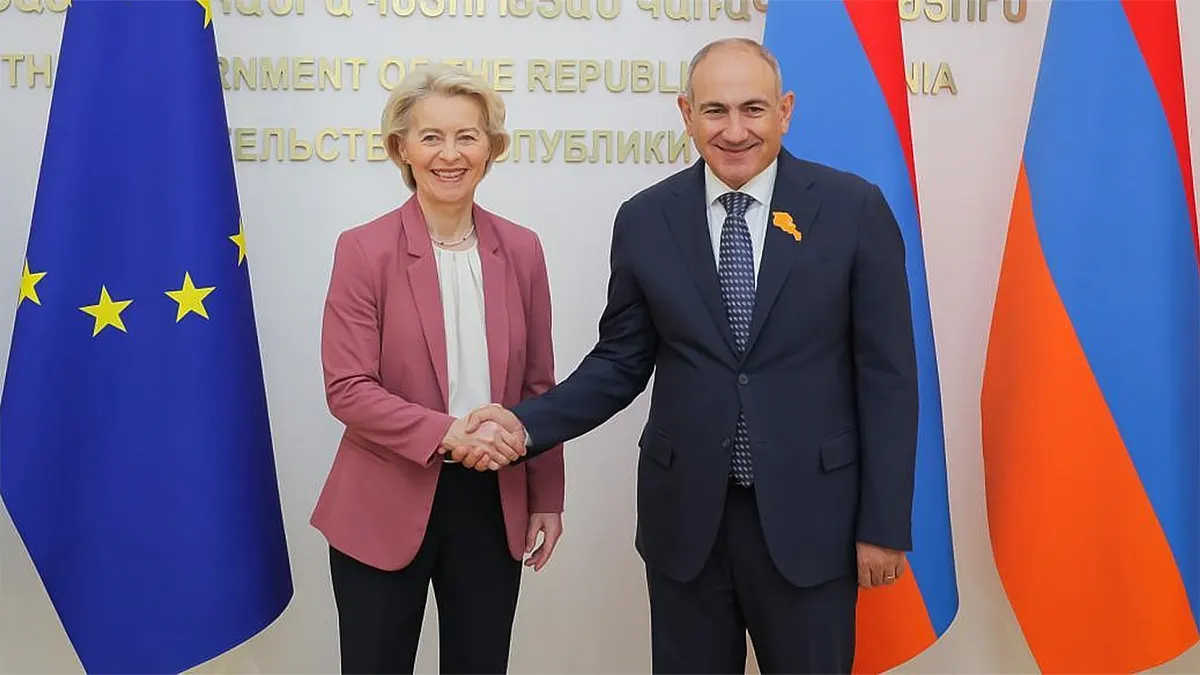 European Commission President Ursula von der Leyen shaking hands with Armenian Prime Minister Nikol Pashinyan in Yerevan, flanked by the European Union and Armenian flags.